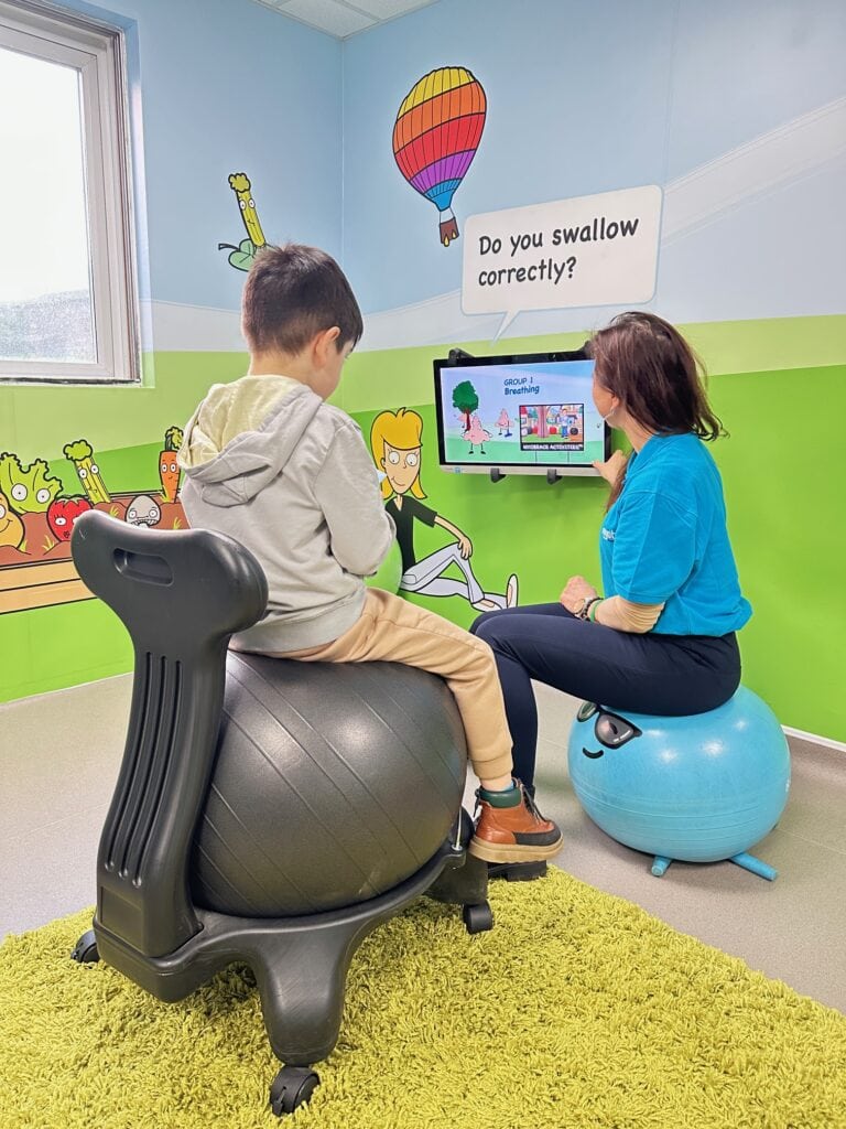 Myobrace educator and young patient watching educational videos together in the dedicated Myobrace room at Optident Dental Clinic in Colchester.